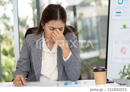 Stressed businesswoman at desk, feeling overwhelmed with paperwork Stressed businesswoman at desk, feeling overwhelmed with paperwork 132892053