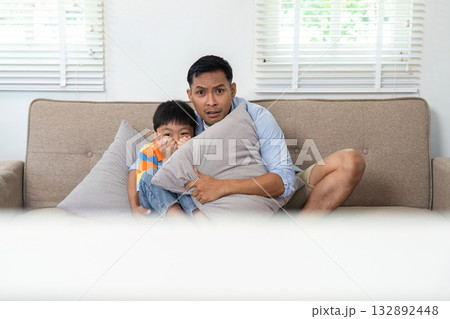Family Bonding and Fun. Father and son enjoying a thrilling movie moment on the couch. 132892448