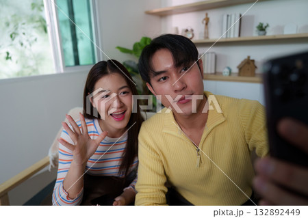 Friendly Interaction. Young couple capturing a selfie while enjoying time together. 132892449