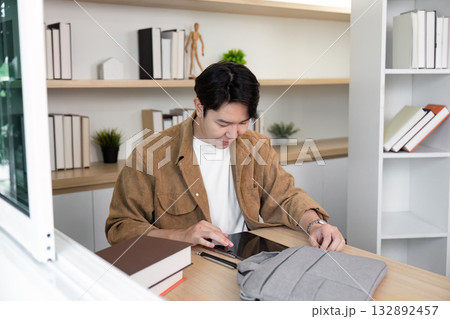 Remote Work and Collaboration. Young man using tablet at modern workspace. 132892457