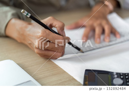 Architect drafting plans with pencil on workspace Architect drafting plans with pencil on workspace 132892484