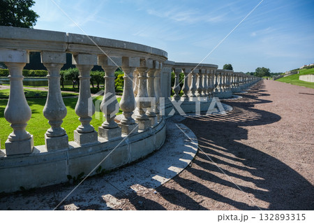A long row of stone pillars with a shadow cast on the ground 132893315