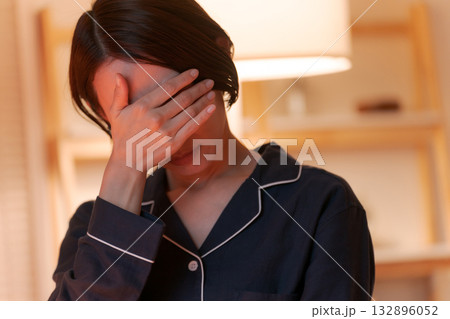 目元を抑えるパジャマの女性 目元を抑えるパジャマの女性 132896052