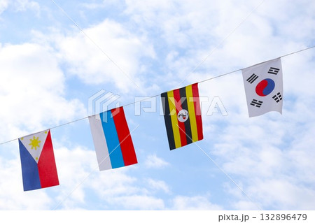 秋の空に舞う万国旗 132896479