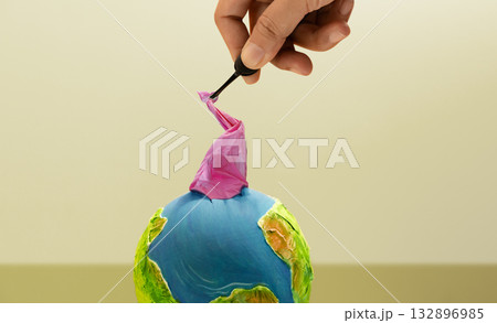 Hand removes plastic waste from Earth, Environmental responsibility Hand removes plastic waste from Earth, Environmental responsibility 132896985