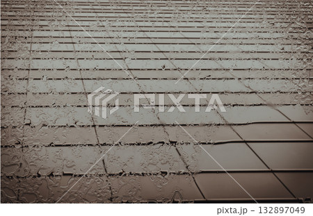 From below, the glass awning glistens, a cascade of raindrops tracing its surface. 132897049