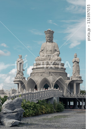 A large white marble statue of Guanyin of the Goddess of Mercy. It is seated on a celestial platform. A large white marble statue of Guanyin of the Goddess of Mercy. It is seated on a celestial platform. 132897055