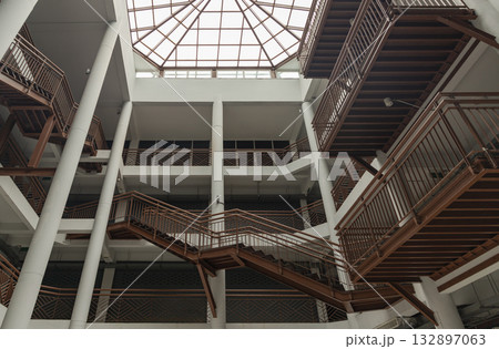 the interior of the Napa Building at Wongwian Yai. The building's design features a contemporary architectural style with a complex arrangement of crisscrossing steel staircases and railings 132897063