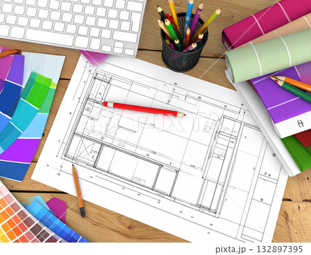 オフィスのデスクに設計図とカラフルなカラーチャートが広がるビジネス風景 132897395
