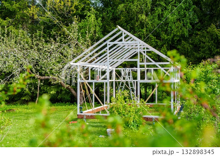 Greenhouse Project Construction in a Sunny Garden. A Symbol of Sustainability and Growth. 132898345
