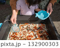 縁日出店で金魚すくいする親子 132900303