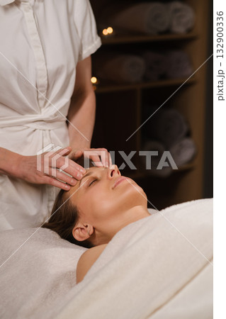 Relaxation during a soothing facial treatment session in a tranquil spa environment with soft lighting and calming atmosphere Relaxation during a soothing facial treatment session in a tranquil spa environment with soft lighting and calming atmosphere 132900336
