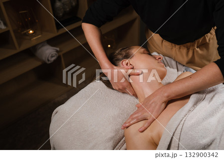 Relaxing neck and shoulder massage at a wellness spa in the afternoon for soothing stress relief and enhancing relaxation Relaxing neck and shoulder massage at a wellness spa in the afternoon for soothing stress relief and enhancing relaxation 132900342