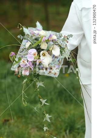Beautiful floral arrangement held by a person in a natural setting showcasing vibrant colors and textures during a sunny day in early spring 132900470