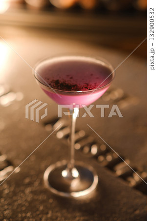 Colorful cocktail served in elegant glass highlights the vibrant atmosphere of a trendy bar at night 132900532