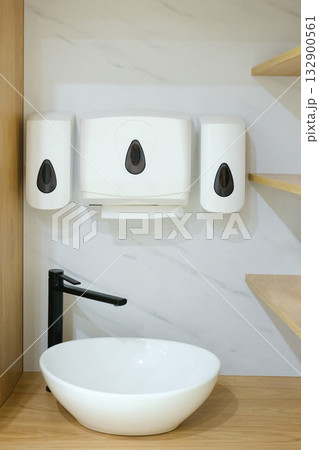 Modern restroom setup featuring a minimalist sink and soap dispenser in a clean, stylish environment, showcasing functionality and contemporary design Modern restroom setup featuring a minimalist sink and soap dispenser in a clean, stylish environment, showcasing functionality and contemporary design 132900561