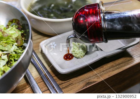 Pour Korean soy sauce into a bowl with wasabi Pour Korean soy sauce into a bowl with wasabi 132900952
