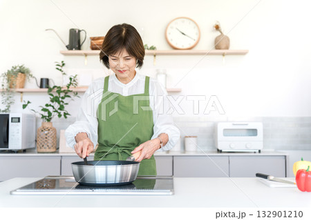 キッチンで料理する中高年の女性（母の味,おふくろの味,クッキング） 132901210