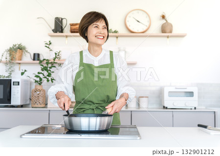 キッチンで料理する中高年の女性（母の味,おふくろの味,クッキング） 132901212