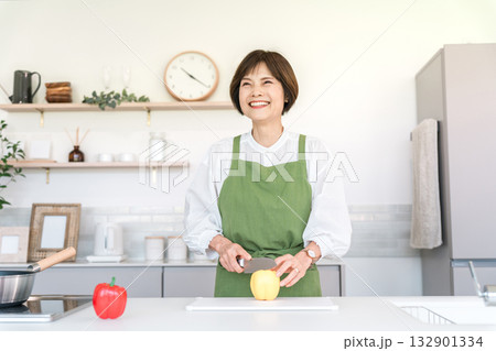 家のキッチンで料理を作るアジア人のシニア女性（カット,まな板,切る） 132901334