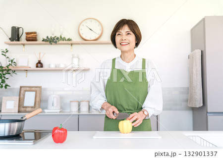 家のキッチンで料理を作るアジア人のシニア女性（カット,まな板,切る） 132901337