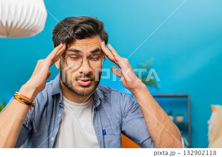 Sick ill Indian man rubbing temples to cure headache problem, suffering from migraine, stress Sick ill Indian man rubbing temples to cure headache problem, suffering from migraine, stress 132902118