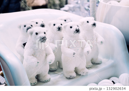 Group of glittery white polar bear plush decorations arranged in a festive retail display. Christmas decor, winter animal theme, whimsical holiday accents, arctic-inspired celebration Group of glittery white polar bear plush decorations arranged in a festive retail display. Christmas decor, winter animal theme, whimsical holiday accents, arctic-inspired celebration 132902634