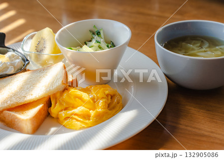 スクランブルエッグとトースト、ヨーグルトとスープを添えた洋風朝食 スクランブルエッグとトースト、ヨーグルトとスープを添えた洋風朝食 132905086