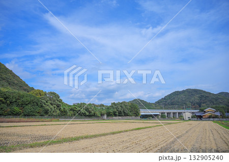 秋空に広がる稲刈り後の田んぼと高速道路の風景 秋空に広がる稲刈り後の田んぼと高速道路の風景 132905240