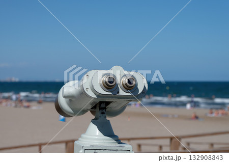 A coin-operated binoculars showing the sandy Playa de las Arenas beach in Valencia, Spain 132908843