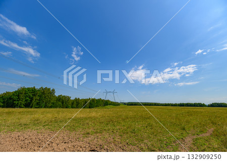 A Vast and Lush Green Field Extending Outward Under a Bright and Clear Blue Sky Above A Vast and Lush Green Field Extending Outward Under a Bright and Clear Blue Sky Above 132909250