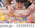 縁日でスーパーボールすくいをする親子 132909253