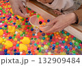 お祭りでスーパーボールすくいをする親子の手 132909484