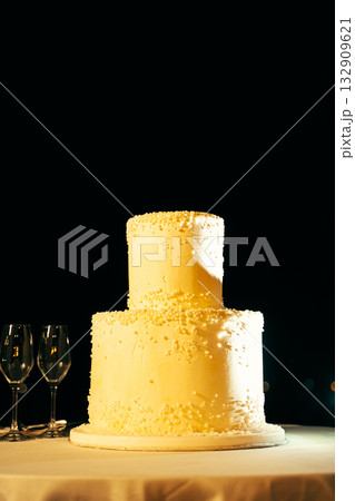 Elegant Two-Tier Wedding Cake with Glasses Beside 132909621