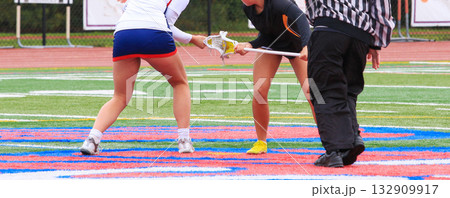 Faceoff in Intense Girls Lacrosse Game on Colorful Field 132909917
