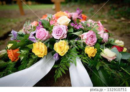 A small funeral wreath of pink, orange, yellow and white roses A small funeral wreath of pink, orange, yellow and white roses 132910751
