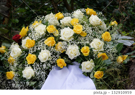 grave arrangement with white and yellow roses 132910959