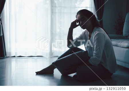 Tired depressed desperate tired girl sadly sitting on couch at home. Young woman is sitting on floor living room, feeling sad and depressed. Psychological problem. Depression and loneliness concept. Tired depressed desperate tired girl sadly sitting on couch at home. Young woman is sitting on floor living room, feeling sad and depressed. Psychological problem. Depression and loneliness concept. 132911050