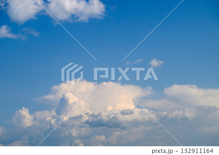 The Serene Blue Sky Filled with Fluffy White Clouds Creates a Beautiful and Peaceful Scene 132911164