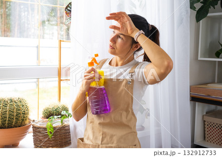 A sad tired woman does not want to wash the windows and clean the house, negative emotions, burnout. Restoring order and cleanliness, cleaning servise A sad tired woman does not want to wash the windows and clean the house, negative emotions, burnout. Restoring order and cleanliness, cleaning servise 132912733