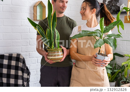 A husband gives his wife a potted plant for a hobby A husband gives his wife a potted plant for a hobby 132912826