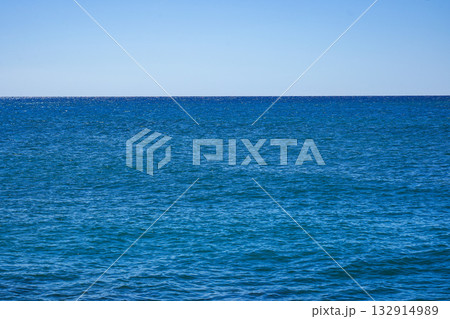Expansive Azure Ocean Under a Clear Sky, Showcasing Tranquil Waters and Endless Horizon as Daylight Illuminates the Serene Coastal View 132914989