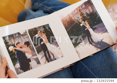 Female hands flipping through a photo book with wedding photos Female hands flipping through a photo book with wedding photos 132915544