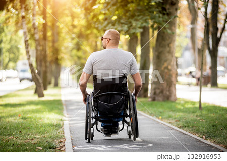Handicapped man in wheelchair walk at the park alley Handicapped man in wheelchair walk at the park alley 132916953
