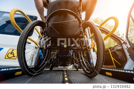 A man in a wheelchair on a lift of a vehicle for people with disabilities 132916982