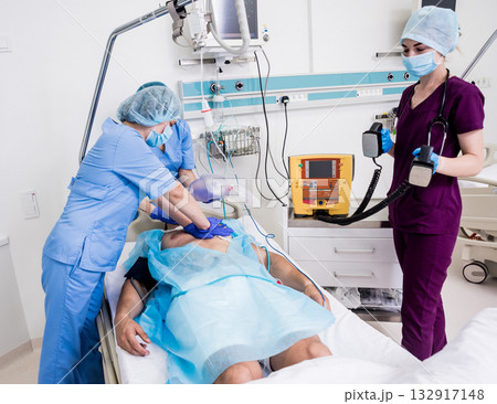Doctors give resuscitation to a male patient in the emergency room. 132917148