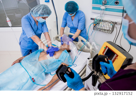 Doctors give resuscitation to a male patient in the emergency room. 132917152