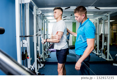 Rehabilitation therapy. Young man doing exercises on mat Rehabilitation therapy. Young man doing exercises on mat 132917235