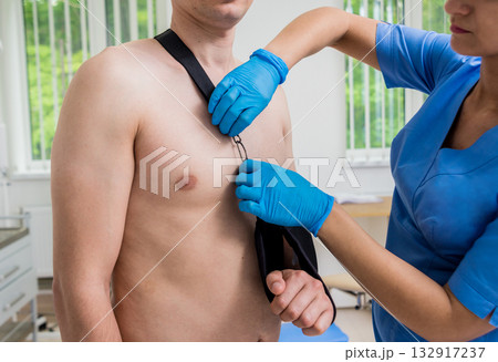 Nurse putting a sling on patients arm that is broken. Injury Nurse putting a sling on patients arm that is broken. Injury 132917237