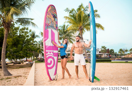 Two young surfers with boards on the beach Two young surfers with boards on the beach 132917461